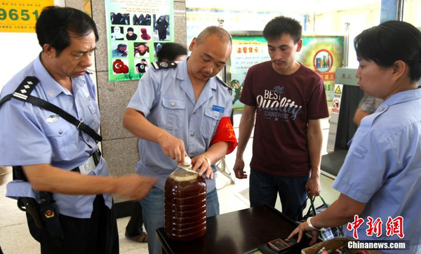 資料圖：7月29日，公安民警和安保人員正在克拉瑪依客運(yùn)站進(jìn)站口嚴(yán)查進(jìn)站旅客行李和違禁物品。 周建玲 攝