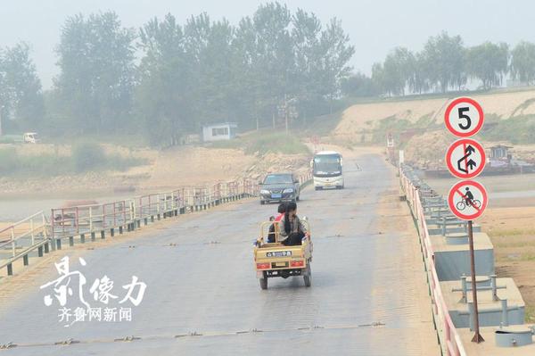 濟南北店子黃河浮橋兩側也設有提示牌，禁止自行車上橋，一輛三輪車慢慢駛向對岸。（圖文 李瑞平）