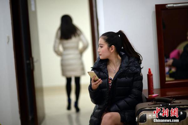 　　換裝后，舉牌女郎在化裝室休息。中新社發(fā) 稻草 攝 圖片來源：CNSPHOTO