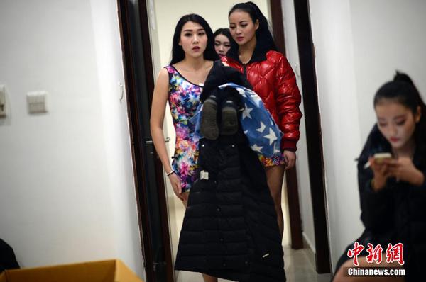 　一位遲到的舉牌女郎剛從化妝間廁所換裝出來。中新社發(fā) 稻草 攝 圖片來源：CNSPHOTO
