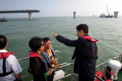 這是2014年4月25日，李崴（右二）在調(diào)研港珠澳大橋建設(shè)情況的資料照片。