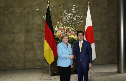 3月9日，在日本東京首相官邸，日本首相安倍晉三（右）歡迎到訪的德國(guó)總理默克爾。新華社發(fā)