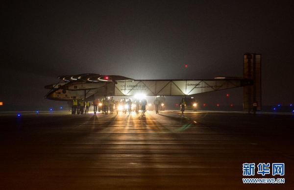 31日凌晨，工作人員在停機坪上推著太陽能飛機向臨時搭建的專用機庫前行。