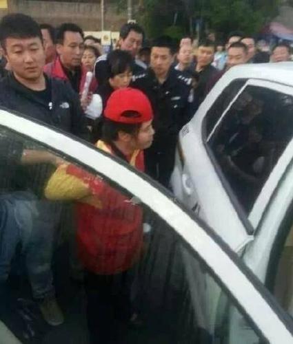 女志愿者被民警帶上警車，受傷女子則被送醫(yī)救治。