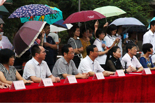 在主席臺上觀看的校領(lǐng)導也堅持不打傘陪學生一起淋雨，身旁站滿了打傘觀看的家長。