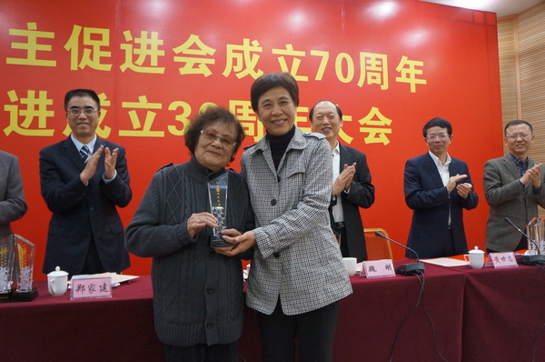 廈門市統(tǒng)戰(zhàn)部部長黃菱給入會60周年97歲高齡的民進會員謝植桂頒發(fā)榮譽獎杯。