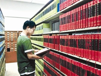 資料圖：一名古籍愛好者正在北大古籍閱覽室翻看“四庫全書”。圖片來源：北京青年報