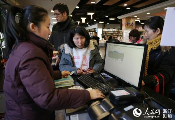 書店服務員幫助市民查閱該書是否可外借。
