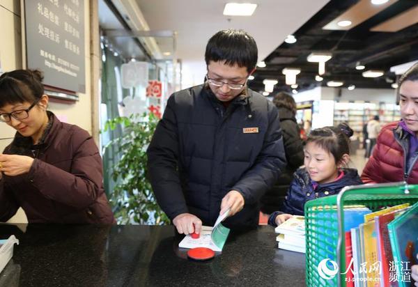 圖書管理員給新書加蓋杭州圖書館公章。