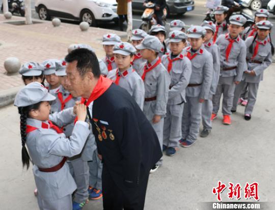 受谷殿明血雷鋒事跡的感染，雷鋒小標(biāo)兵為這位“活雷鋒”爺爺系上紅領(lǐng)巾?！」鶊@ 攝