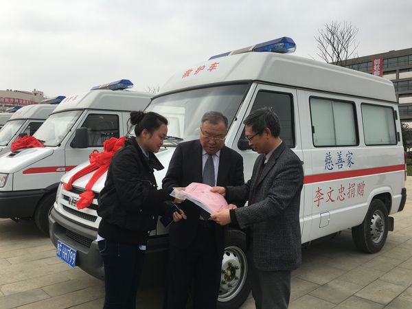 李文忠（中）與畢節(jié)市衛(wèi)計(jì)委工作人員辦理巡診車交付使用的手續(xù)，右為畢節(jié)市衛(wèi)計(jì)委主任鄧韜。