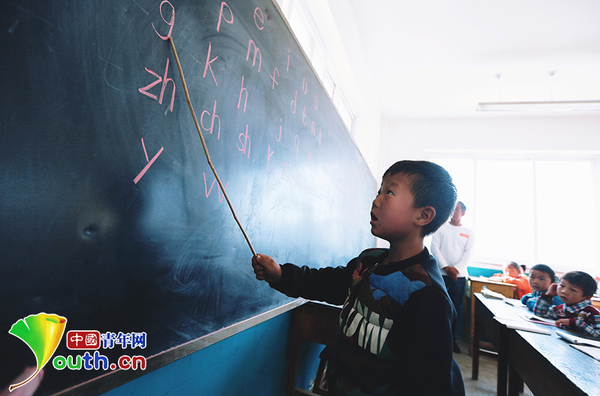 　　6歲的楊嚴國熟練地讀著黑板上的拼音字母。