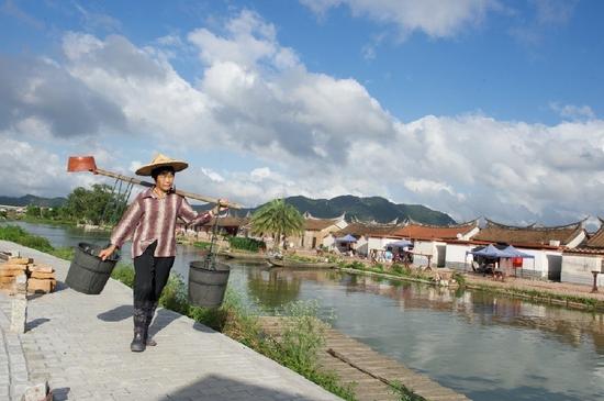 5月27日，埭美村一位村民挑桶經(jīng)過村前小河