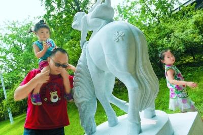 排隊購買“猴年馬月”特色郵品后，人們喜歡摸一摸“馬上封侯”的雕塑，為家人祚福。