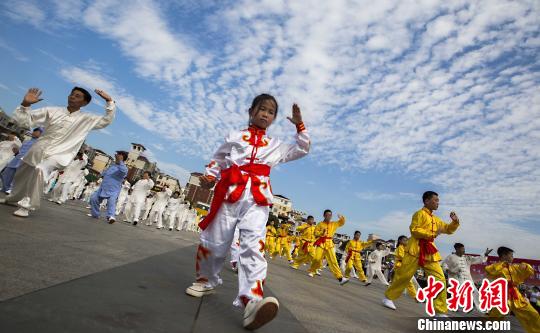 少年太極拳愛好者在江西都昌縣一廣場上表演太極拳?！「到ū蟆z