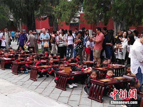 　　9月1日，有小學(xué)在北京孔廟舉行入學(xué)“開筆禮”儀式，小學(xué)生穿著漢服，周圍還有家長。中新網(wǎng)記者 宋宇晟 攝