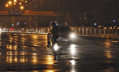 昨日，大望路，行人正在冒雨過人行道。 新京報記者 王飛 攝