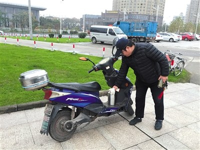 11月20日，陳思騎電動(dòng)車巡江。由于每次出去就是一整天，他都會(huì)自備一個(gè)水壺。