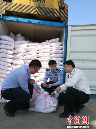 圖為海關關員、緝私警察查看涉嫌走私大米 周磊 攝