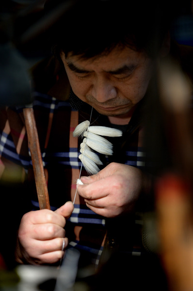 一位師傅在進(jìn)行捆頭工序的制作。