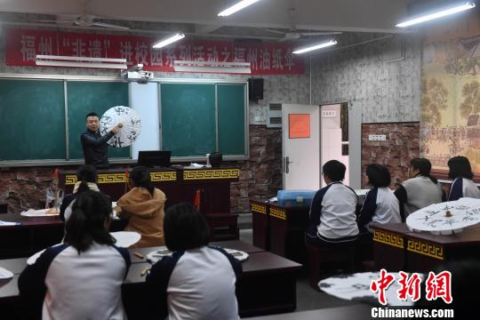 嚴(yán)磊在課堂上講授如何進(jìn)行油紙傘包頂，17名學(xué)生紛紛抬起頭聽講?！蚊?攝