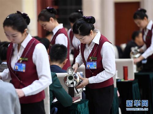 3月6日，北京華北賓館的女服務員在民盟、無黨派人士界委員聯(lián)組會上倒水。在兩會會場內外，女代表、女委員、女工作人員、女記者在工作中盡職盡責，展現(xiàn)著自己的風采。 新華社記者張鐸攝