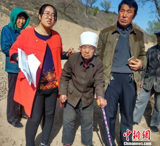 王萬芳在貧困戶入戶調查時，走進演武鄉(xiāng)佛岔村馬忠玲家和殘疾老人在一起。　侯志雄 攝