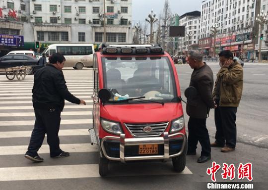 營山城區(qū)電動四輪車司機正在討論車輛的車況?！⒅铱?攝