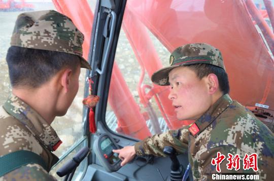 武警交通第二支隊(duì)四大隊(duì)達(dá)東村訓(xùn)練基地挖掘機(jī)二班班長(zhǎng)張凱華(右)手把手教學(xué)員操作細(xì)節(jié) 郭江宸 攝