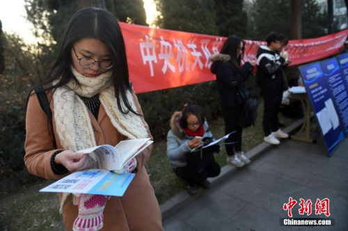 資料圖：2016年11月27日，山西太原一國考考點(diǎn)，考生在考場外看書復(fù)習(xí)。武俊杰 攝