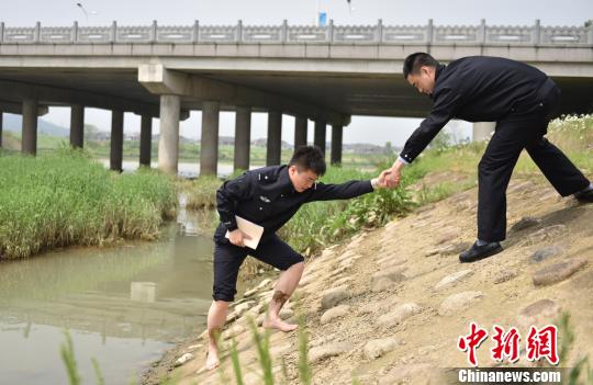 圖為：臧建軍勘察河道現(xiàn)場(chǎng)?！⌒蠘芬?攝