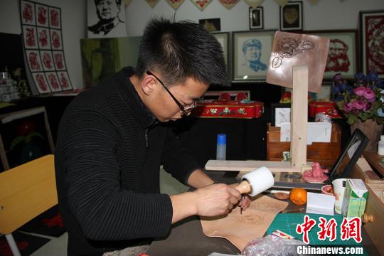 圖為魏康龍正在制作皮雕?！顤|東 攝