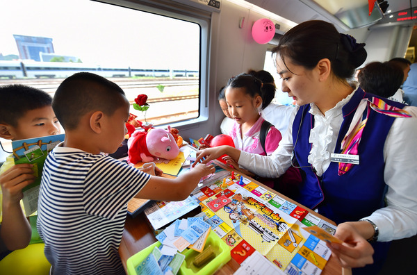 北京鐵路局天津客運(yùn)段值乘的廈門北至北京南G324次列車乘務(wù)員與兒童旅客互動(dòng)做游戲。