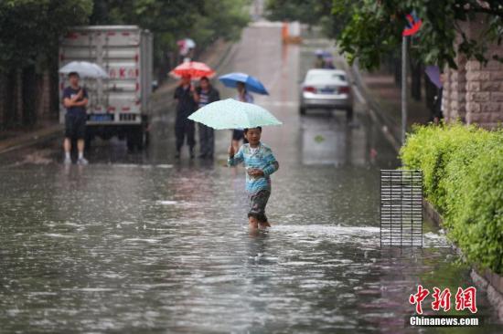 6月12日，市民在積水的道路中出行。當日，貴陽市氣象臺于6時28分將暴雨黃色預(yù)警信號升級為暴雨紅色預(yù)警信號，持續(xù)降雨造成貴陽市多處路段嚴重積水。<a target='_blank' href='http://www.chinanews.com/'>中新社</a>記者 賀俊怡 攝