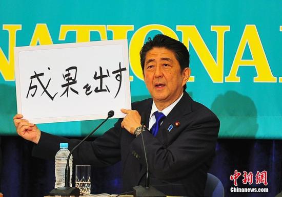 日本參議院選戰(zhàn)在即，6月21日在日本記者俱樂部進(jìn)行的選前黨首辯論會(huì)上，“安倍經(jīng)濟(jì)學(xué)”的成敗功過再度成為熱辯之題。圖為安倍現(xiàn)場高調(diào)亮出“搞出成果”字牌。<a target='_blank' href='http://www.chinanews.com/'>中新社</a>記者 王健 攝