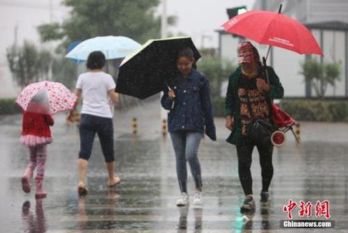 資料圖：民眾在雨中出行。