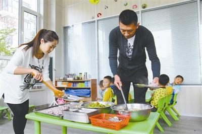 逄秋香、陳亮夫妻倆為幼兒園孩子盛午飯。
