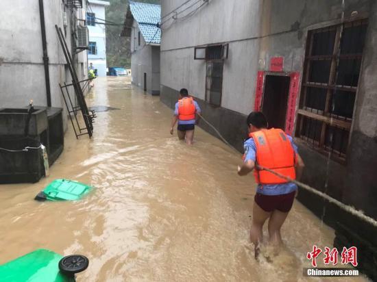 圖為浙江省麗水市遂昌縣民警在積水中準(zhǔn)備營(yíng)救居民。