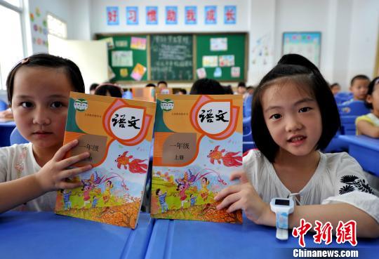 資料圖：小學(xué)新生展示語文教材?！埍?攝