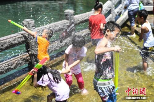 7月11日，幾名兒童在山東濟(jì)南“清泉石上流”池中戲水納涼。山東近日持續(xù)高溫，多地發(fā)布橙色高溫預(yù)警，局部地區(qū)氣溫達(dá)到39℃。<a target='_blank' href='http://www.chinanews.com/'>中新社</a>記者 張勇 攝