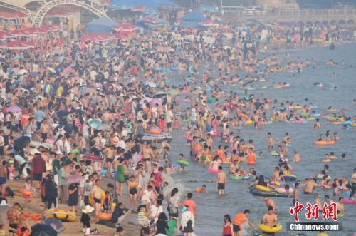 2017年7月12日，青島市第一海水浴場(chǎng)日迎數(shù)萬游客前來避暑納涼。<a target='_blank' href='http://www.chinanews.com/'>中新社</a>發(fā) 王海濱 攝 圖片來源：CNSPHOTO