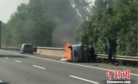圖為：杭甬高速寧波段一輛面包車側翻后起火，好心人救一家7口。　何蔣勇 攝
