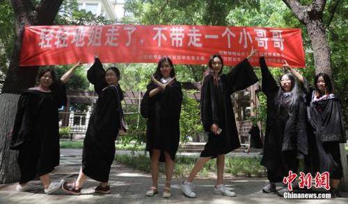 6月9日，幾名畢業(yè)生在北京工業(yè)大學(xué)校園內(nèi)合影，校園里懸掛著北京部分高校畢業(yè)季里特有的“任性”條幅。<a target='_blank' href='http://www.chinanews.com/'>中新社</a>記者 楊可佳 攝