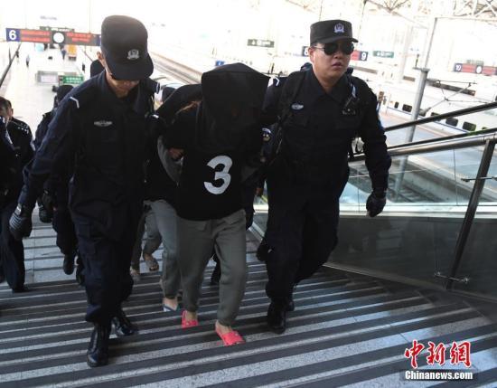 8月29日，在長春火車站，10名電信詐騙犯罪嫌疑人被長春警方從緬甸經(jīng)云南押解回國。據(jù)悉，這十名犯罪嫌疑人自2013年1月開始作案235起，跨24個(gè)省、自治區(qū)、直轄市，涉案金額360萬元人民幣。 中新社記者 張瑤 攝