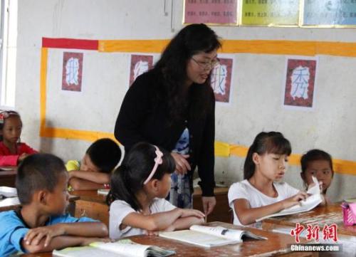 9月22日，在偏遠山區(qū)的廣西柳江縣穿山鎮(zhèn)六廟小學，幾間瓦房教室、宿舍，操場上3張乒乓球臺就是學生和老師的一切。48歲的韋鳳玲在給學生們上課，“下雨時，人在上課雨從頭頂落”，韋鳳玲這樣形容學校環(huán)境。2014年從老撾完成兩年支教任務(wù)的柳江縣第二中學教師韋鳳玲，又到該縣土博鎮(zhèn)、穿山鎮(zhèn)村級小學支教，被稱為支教“專業(yè)戶”。朱柳融 攝