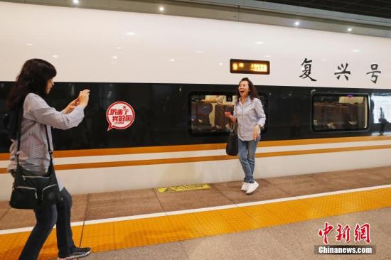 資料圖：旅客與“復(fù)興號(hào)”列車合影留念。殷立勤 攝