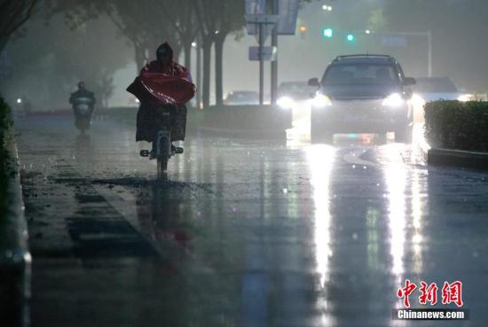 北京市民在雨中前行。 <a target='_blank' href='http://www.chinanews.com/'>中新社</a>記者 劉關(guān)關(guān) 攝