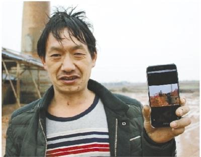 1月27日，嚴(yán)國有向記者展示他手機(jī)上的照片——老板用來抵工資的大量紅磚?，F(xiàn)在，他身后堆放紅磚的地方已經(jīng)成了空地。