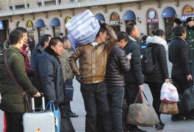 　昨日，北京站，乘客背著行李準(zhǔn)備進(jìn)站乘車。本版攝影/新京報(bào)記者 王貴彬 朱駿 實(shí)習(xí)生 陳婉婷