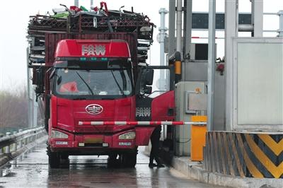 4月13日，京津高速臺(tái)湖收費(fèi)站，一名大貨車(chē)司機(jī)從車(chē)上下來(lái)取高速卡。本版攝影/新京報(bào)記者 朱駿